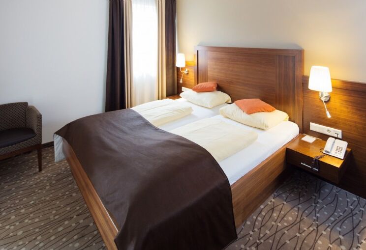 Doppelbett im Hotelzimmer mit Nachttisch